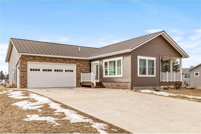 single story home featuring a garage, metal roof, and driveway