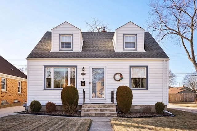 cape cod-style house with a front yard