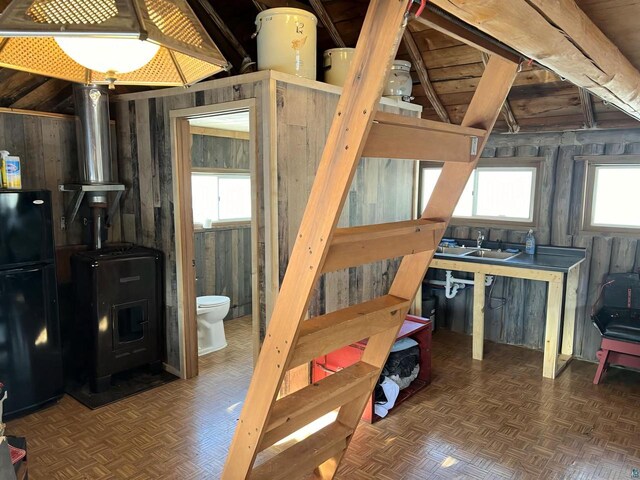 13770 State Highway 13, Herbster, WI 54844 - bedroom featuring wood walls, sink, a wood stove, dark parquet flooring, and black fridge