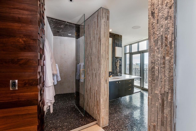 bathroom with vanity, a wall of windows, and walk in shower