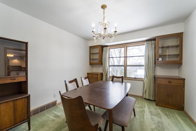 dining room featuring light carpet and an inviting chandelier