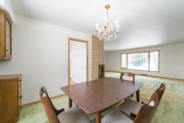 carpeted dining space with a brick fireplace and an inviting chandelier