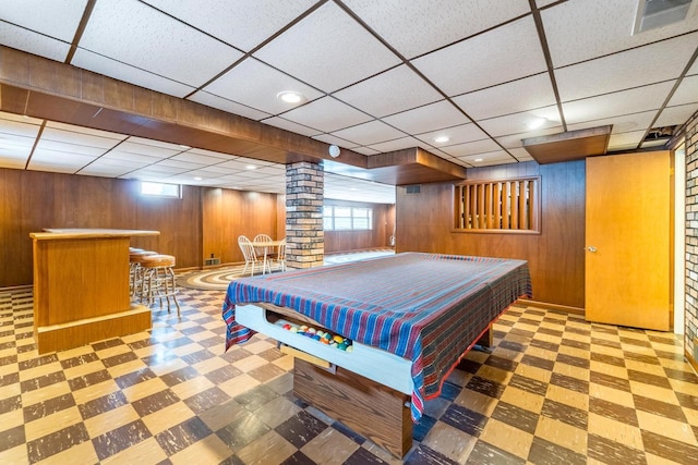 recreation room with billiards, bar, decorative columns, and wood walls