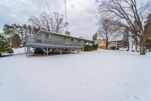 snow covered house with a wooden deck