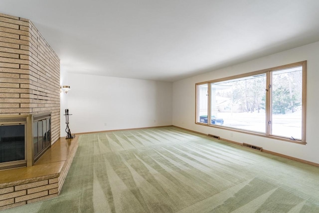 unfurnished living room with a brick fireplace and carpet flooring