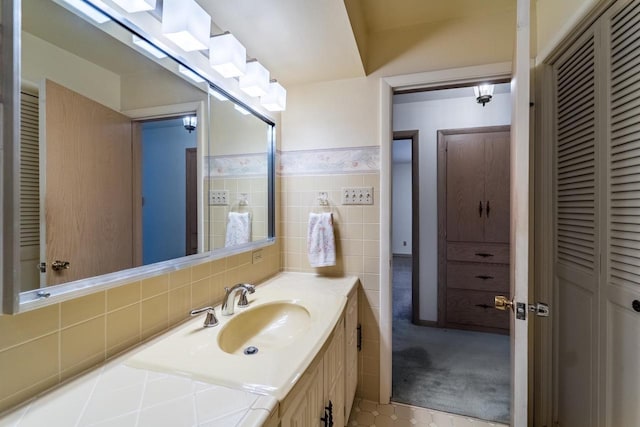 bathroom featuring vanity, tasteful backsplash, and tile walls