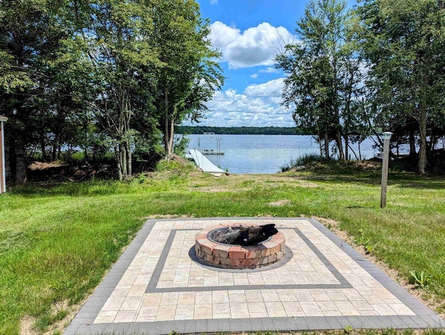 view of yard featuring a water view, an outdoor fire pit, and a patio