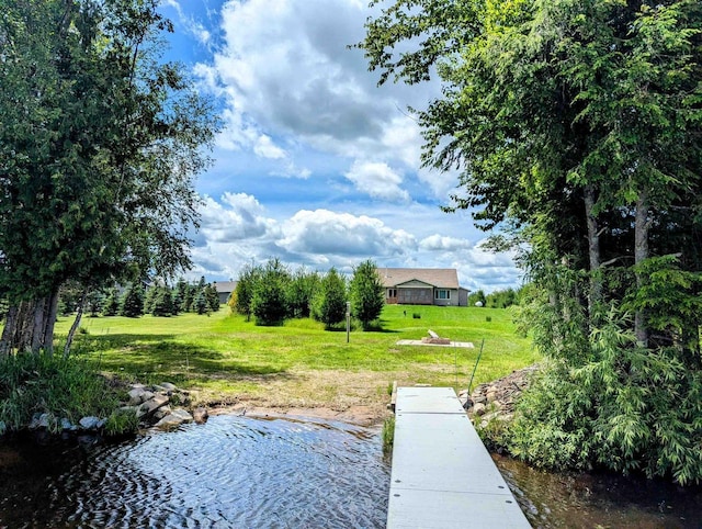 view of dock featuring a lawn