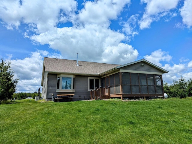 back of property with a yard and a sunroom