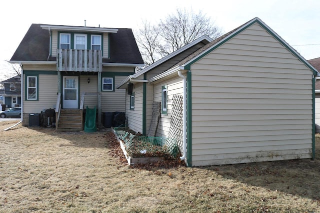 back of property featuring a yard and central AC