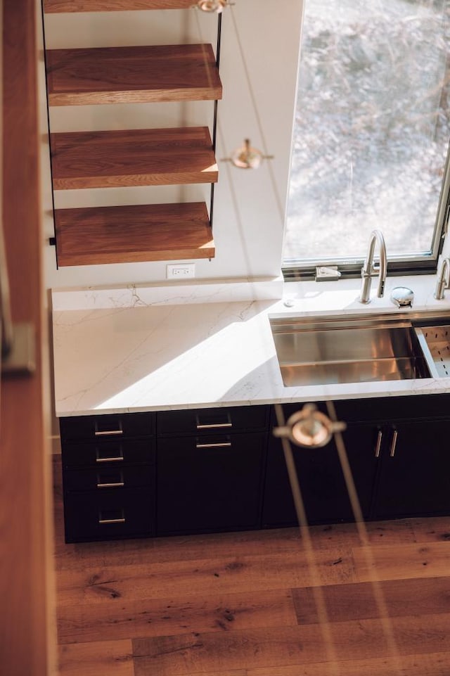 kitchen with light stone counters, dark hardwood / wood-style flooring, and sink