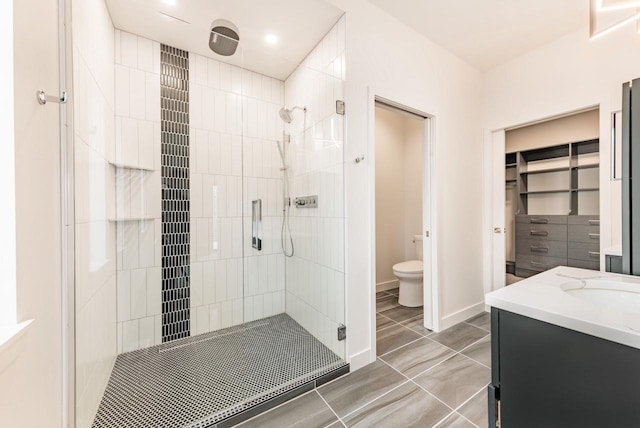 bathroom featuring vanity, tile patterned floors, a shower with door, and toilet