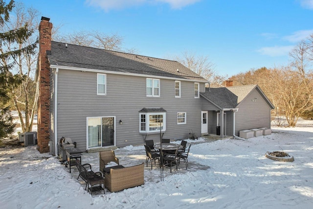 snow covered rear of property with cooling unit