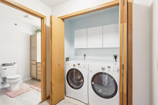 laundry area featuring cabinets and washer and clothes dryer