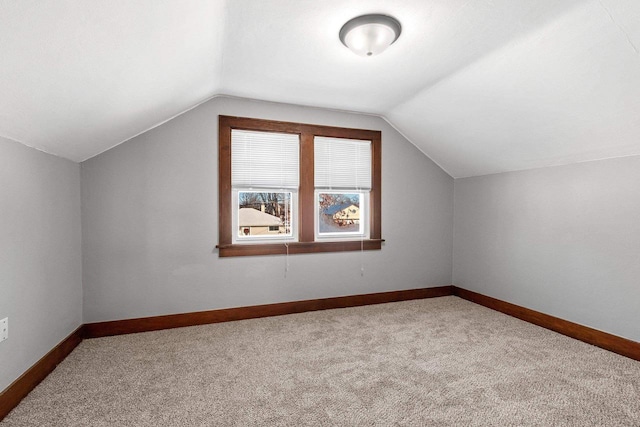 bonus room featuring vaulted ceiling and carpet