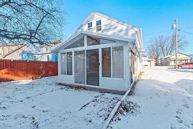 snow covered property featuring a sunroom