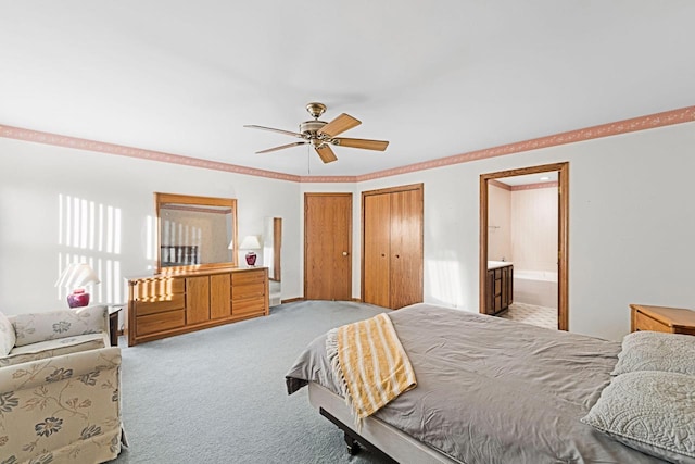 carpeted bedroom with crown molding, ceiling fan, connected bathroom, and two closets