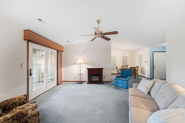 living room with ceiling fan with notable chandelier, carpet floors, and french doors