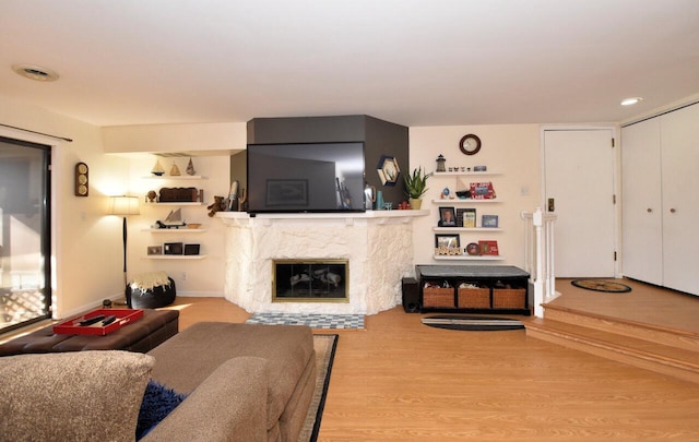 living room featuring light hardwood / wood-style flooring and a high end fireplace