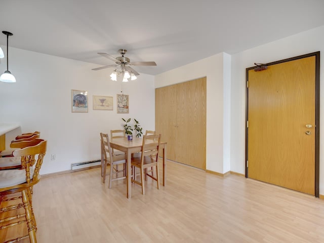 dining room with ceiling fan, a baseboard radiator, and light wood-type flooring