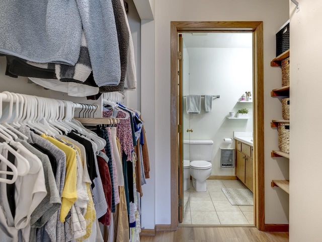 walk in closet with heating unit and light hardwood / wood-style floors