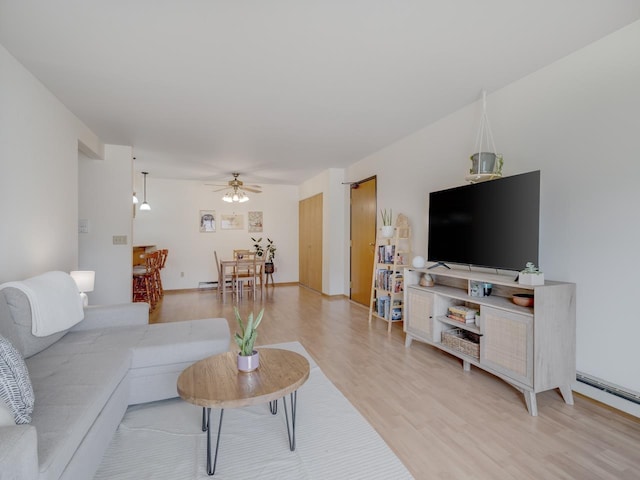 living room featuring wood-type flooring and ceiling fan