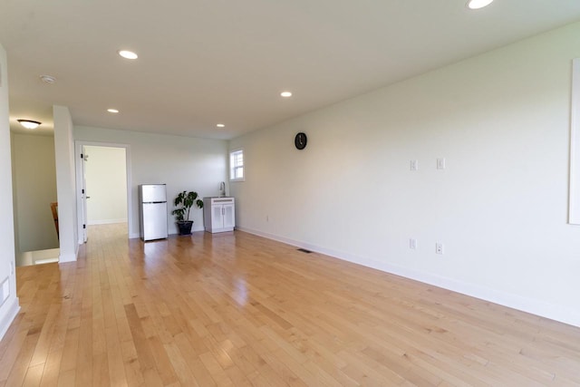 empty room featuring sink and light hardwood / wood-style flooring