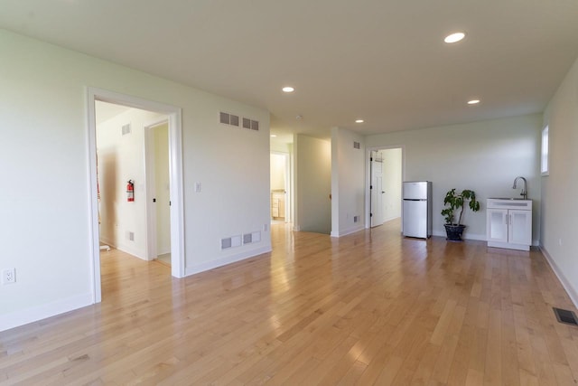 empty room featuring sink and light wood-type flooring