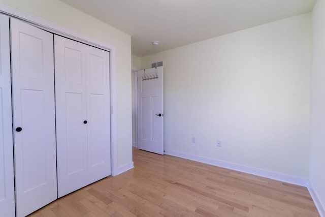 unfurnished bedroom featuring a closet and light wood-type flooring