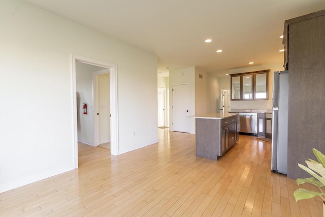 kitchen with appliances with stainless steel finishes, a center island, and light hardwood / wood-style floors