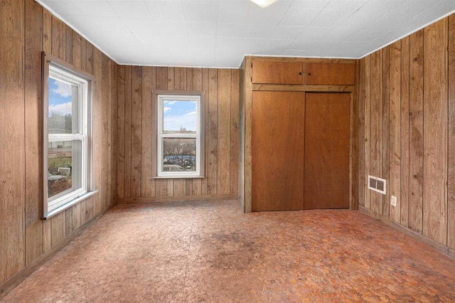 empty room with a healthy amount of sunlight and wood walls