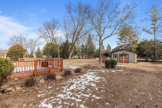 snowy yard featuring a storage unit and a deck