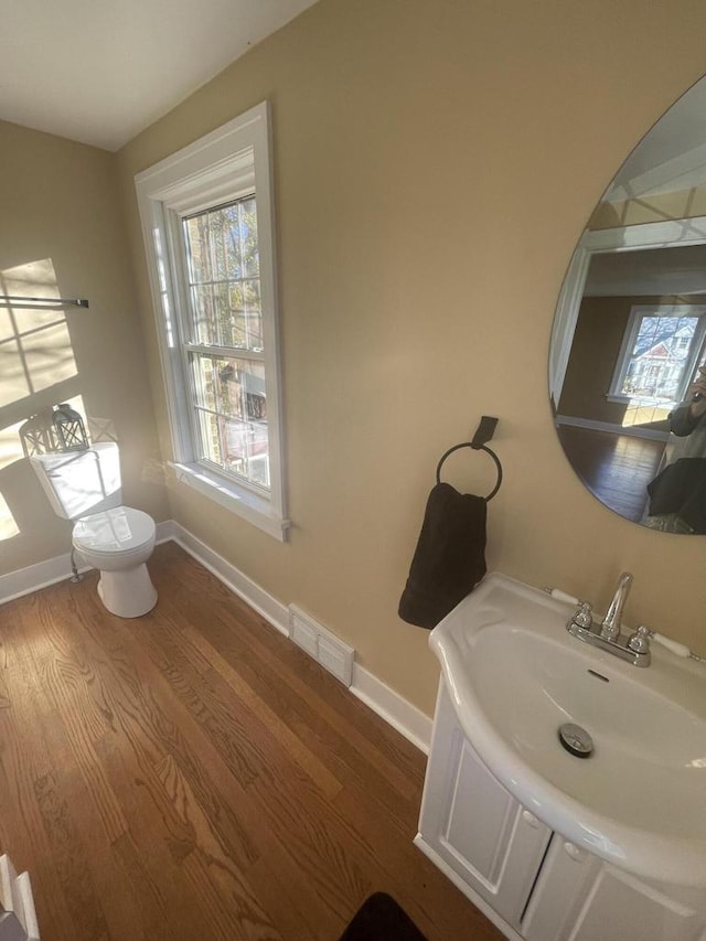 bathroom with hardwood / wood-style flooring, vanity, and toilet