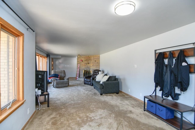 carpeted living room with a stone fireplace