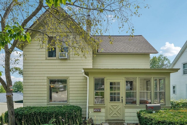 rear view of property featuring a sunroom