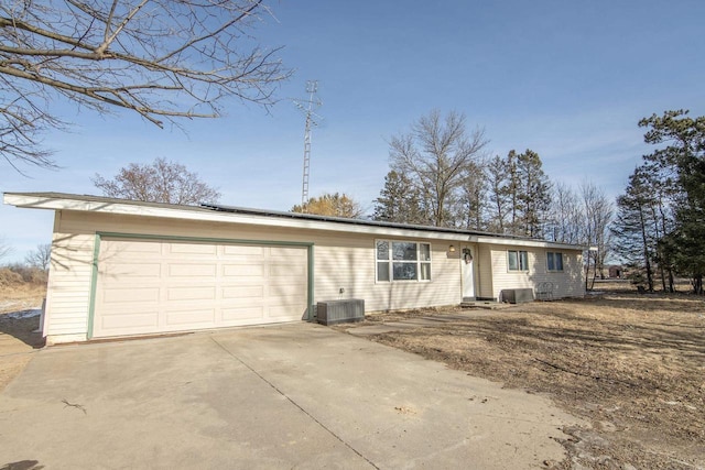 ranch-style house with a garage and central air condition unit