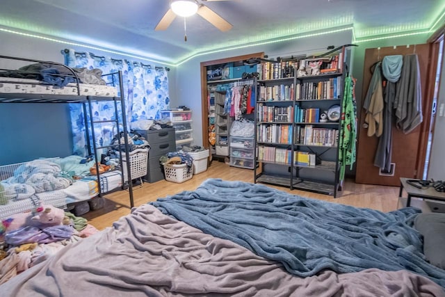 bedroom with lofted ceiling, hardwood / wood-style flooring, a closet, and ceiling fan