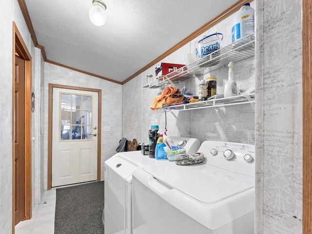 laundry room featuring ornamental molding, separate washer and dryer, and a textured ceiling