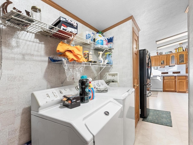 laundry room with ornamental molding, washing machine and dryer, and a textured ceiling