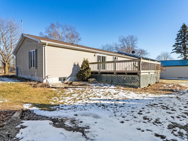 snow covered house with a wooden deck