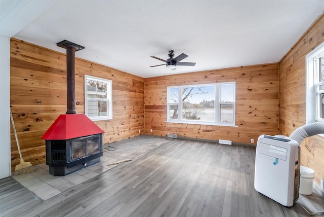 N3005 Lakeview Dr, Montello, WI 53949 - misc room featuring hardwood / wood-style floors, wooden walls, ceiling fan, and a wood stove
