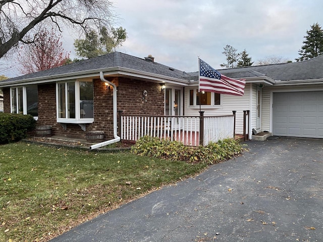 ranch-style home with a garage, a front lawn, and a porch