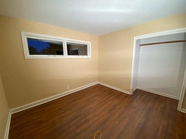 unfurnished bedroom featuring dark hardwood / wood-style flooring and a closet