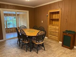 dining area featuring wooden walls and ornamental molding