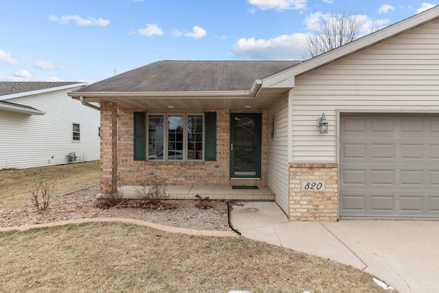 entrance to property featuring a porch, a garage, and a yard