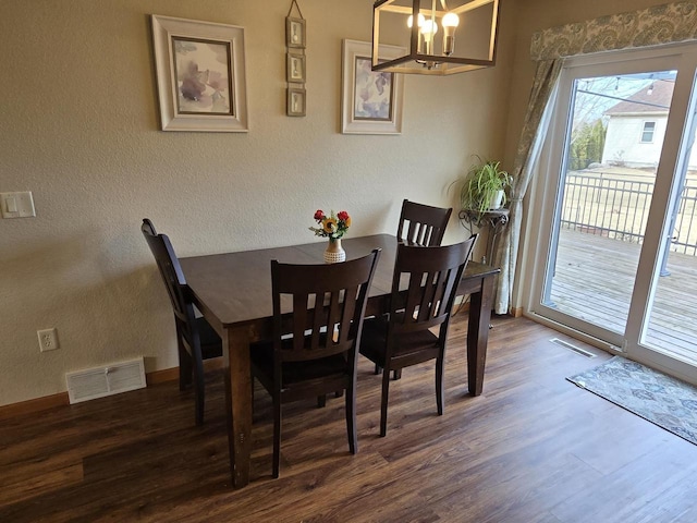 dining room featuring dark wood-type flooring and a chandelier