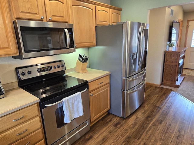 kitchen featuring stainless steel appliances and dark hardwood / wood-style floors