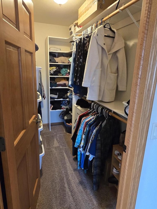 spacious closet featuring dark carpet