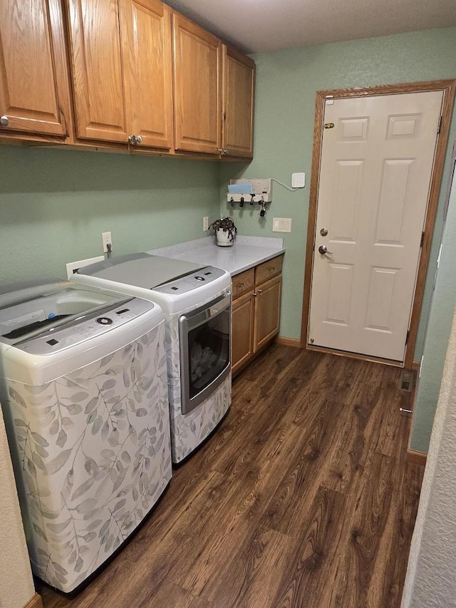 clothes washing area with cabinets, independent washer and dryer, and dark hardwood / wood-style flooring