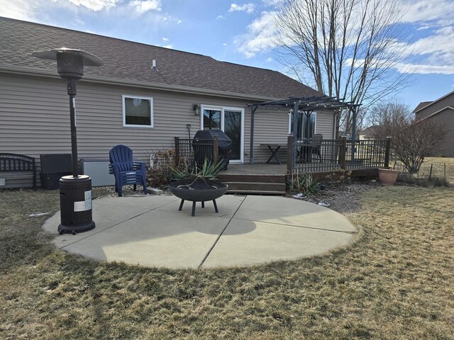 rear view of house with a lawn, a deck, a pergola, a patio, and an outdoor fire pit